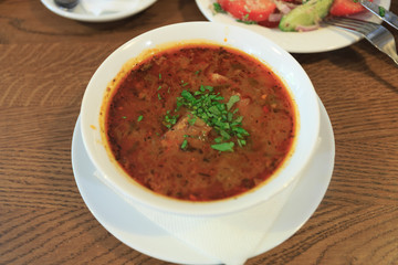 Traditional Georgian soup Kharcho with meat and rice on wooden background