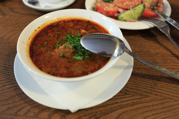 Traditional Georgian soup Kharcho with meat and rice on wooden background