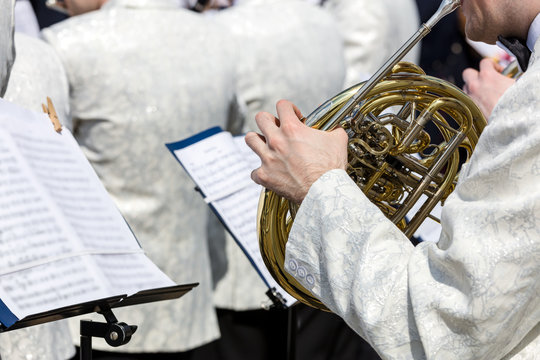 orchestra musician playing french horn during street music fest