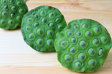 Lined Up Fresh Green Lotus Seeds in Lotus Pods on Wooden Table