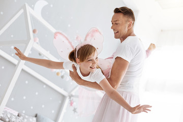 Inspiring active father helping his daughter flying