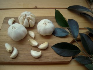 .Garlic whole and garlic cloves on a cutting board and bay leaves......