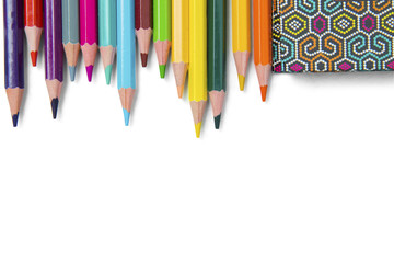 Multicolored pencils and book on white background