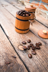 Coffee beans in a barrel on a wooden.