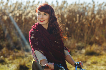 Fototapeta na wymiar Pretty girl riding bicycle in field