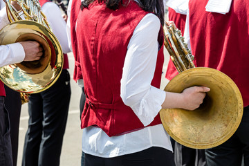 young musicians of brass band playing french horns during street music fest