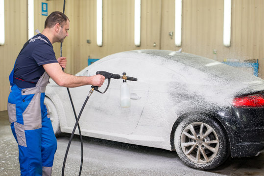 A man washes a black car