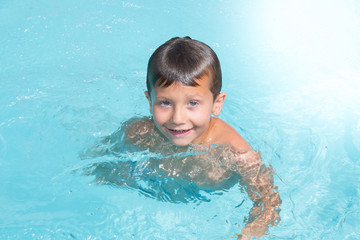Fototapeta na wymiar cheerful kid boy in pool in home