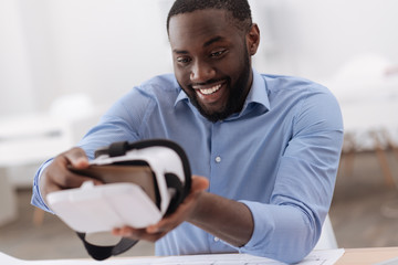 Nice positive man holding a smartphone