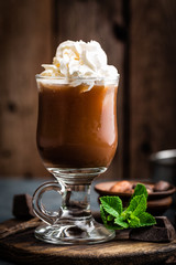 Iced cocoa drink with whipped cream, cold chocolate beverage, coffee frappe on dark background