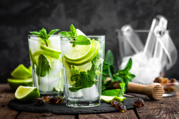 Mojito cocktail à la menthe rafraîchissant avec rhum et citron vert, boisson froide ou boisson avec de la glace sur fond noir