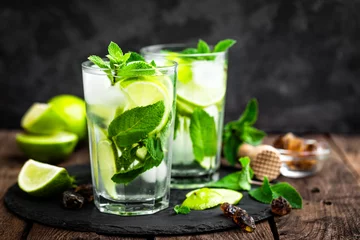 Foto auf Acrylglas Erfrischender Minzcocktail Mojito mit Rum und Limette, Kaltgetränk oder Getränk mit Eis auf schwarzem Hintergrund © Sea Wave