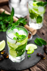 Refreshing mint cocktail mojito with rum and lime, cold drink or beverage with ice on black...