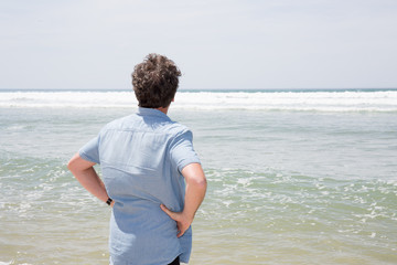 Fototapeta na wymiar back view of man alone on beach summer