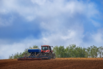 Obraz premium Farmer in tractor preparing land with seedbed cultivator