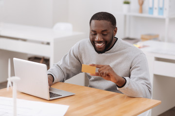 Positive happy man holding a credit card
