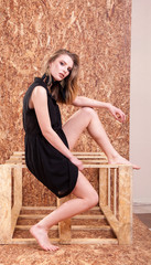 Beautiful blonde in fashion style posing on wooden wall in studio photo. Style and vogue