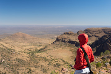 Fototapeta na wymiar Tourist standing on rock and looking at the panoramic view in Marakele National Park, one of the travel destination in South Africa. Concept of adventure and traveling people.