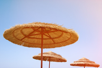 Cane wicker beach umbrellas close against the sky in Sunny weather. The horizontal frame.