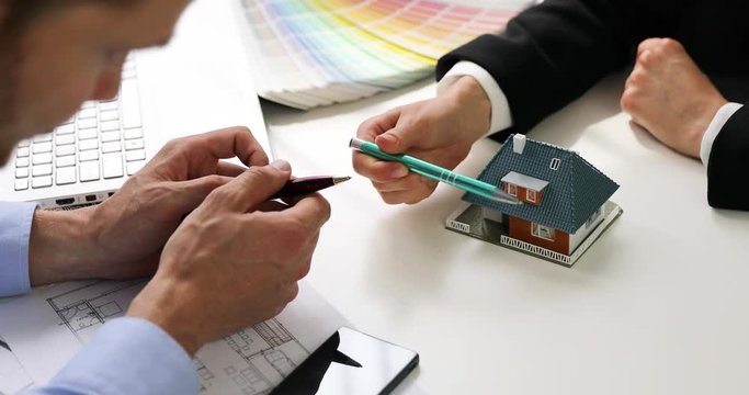 architect showing new family house model to customer at office