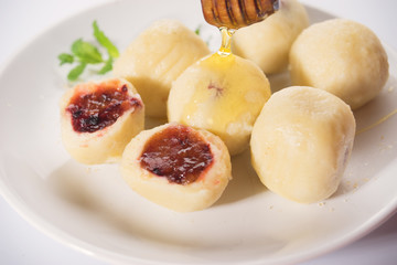 Close up of sweet plum dough dumplings in white plate