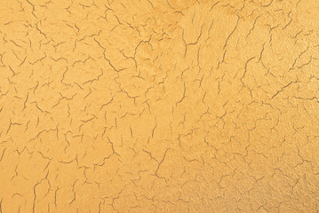 Gold texture with effect of craquelure. Decorative plaster. Interior wall decoration. Top view.