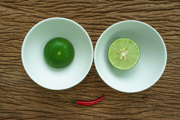 cut lemon in white bowls and chili set up as smiling face use as spicy concept.