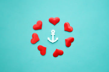 An anchor and hearts on a blue background © Maisterix