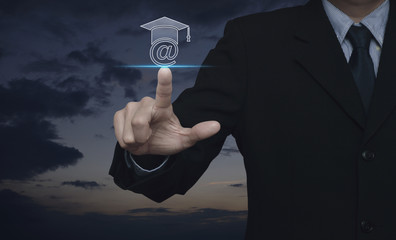 Businessman pressing e-learning icon over sunset sky, Study online concept