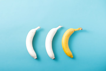 White and yellow bananas on pastel blue background. Minimal fashion, flatlay , top view. Albino Different Creativity Creative Thinking Ideas Concept