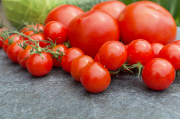 red tomatoes on a branch and board