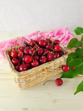 Cherries in a wicker basket on a wooden table
