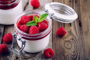 Italian dessert panna cotta with raspberry sauce, fresh berries and mint