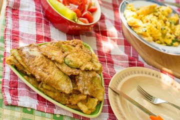 Served lunch with tomato salad and fried zucchini