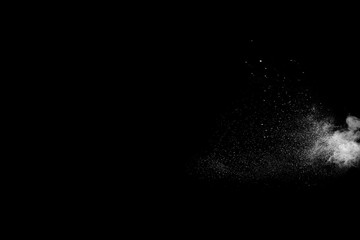 Powder explosion. Closeup of  white particle explosion isolated on black background
