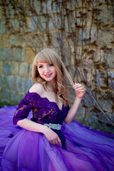 Fototapeta premium blonde girl in violet dress plays with her hair