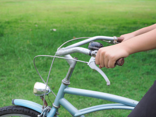 hand with bicycle handle and bike part for firm and fit body exercise on the field of people, vintage style performing on riding.