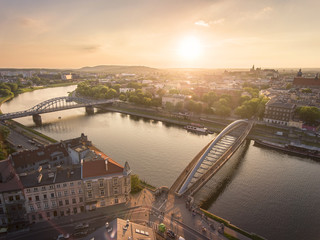 Fototapeta Aerial view at stunning sumer sunset, people walking through Bernatka bridge over Vistula river in Krakow, Poland. obraz