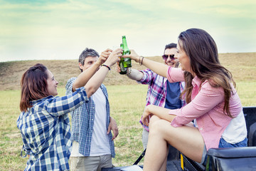 Happy group of young friends toasting with beer