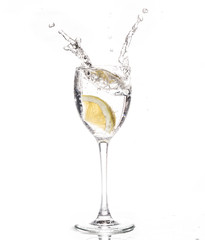 Lemon slice falls in a glass of water - Splash