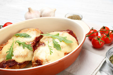 Chicken parmesan with spices in baking dish on table