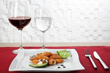 Plate with delicious coconut shrimps on table