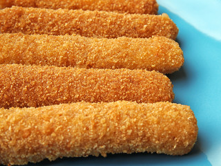 Tasty cheese sticks on plate, closeup