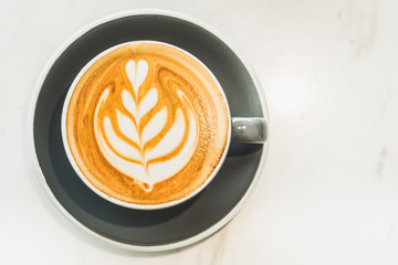 top view of Hot cappuccino coffee cup on white marble stone table