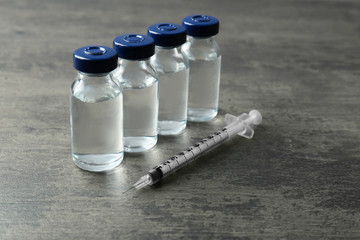 Vaccine in vials with syringe on grunge background