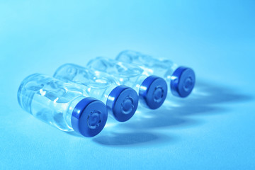 Medical ampules on colour background. Vaccination concept