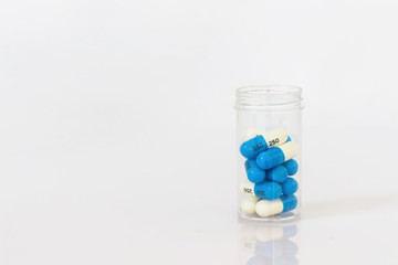 Capsule pills white and blue in a bottle isolated on white background.Image for Health Concept