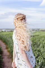 Summer portrait of beautiful blonde lady in wheat field