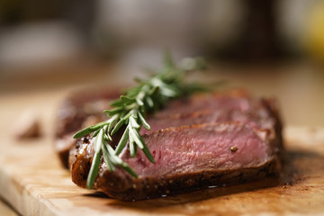 sliced medium rib eye steak with rosemary branch