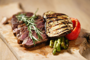 sliced medium rib eye steak with grilled vegetables
